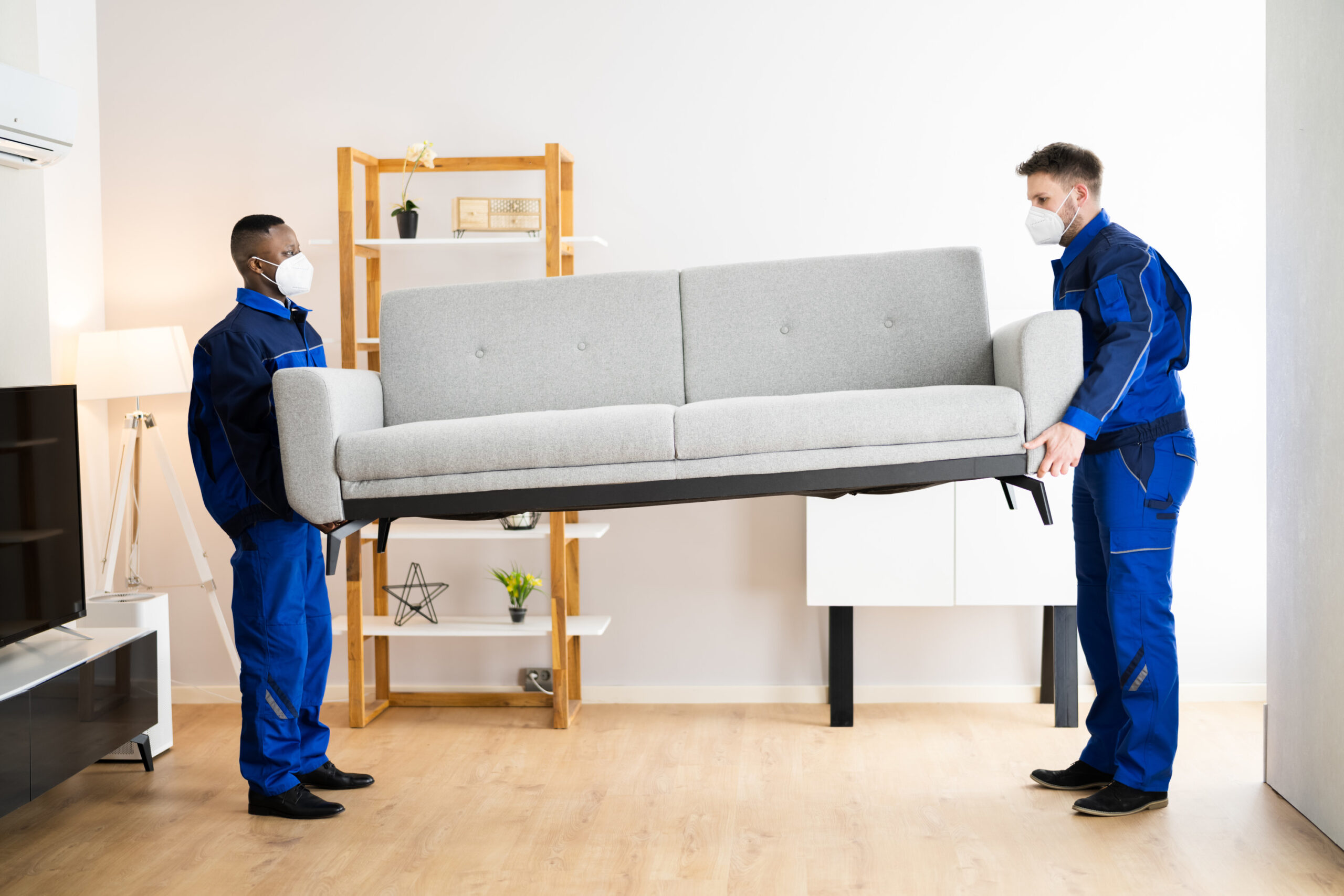 Furniture removal services Kent WA professionals safely lifting and removing a sofa from a residential living room.